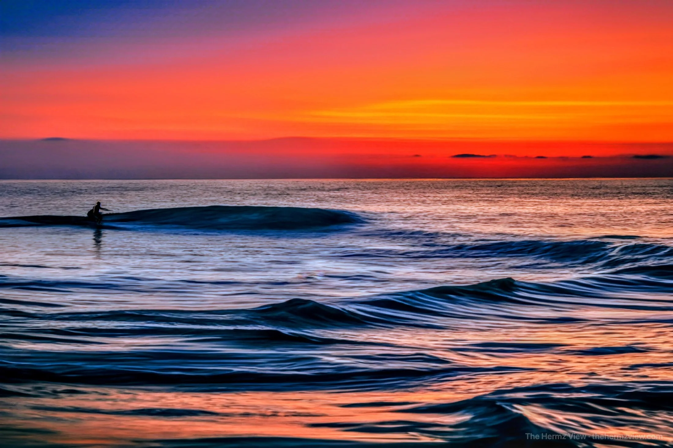 Surfer silhouetted against a glowing sky