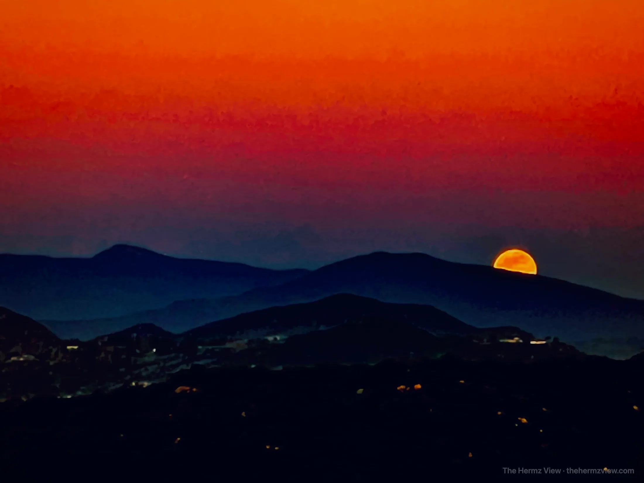 Moon rising above distant ridgelines